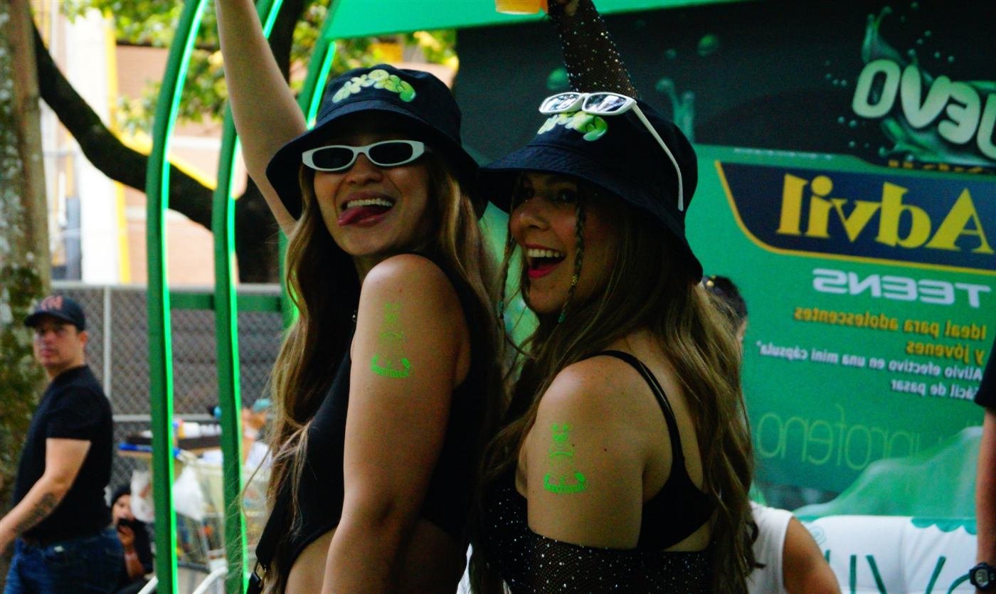 Dos asistentes con tatuajes temporales en una activación de marca al aire libre