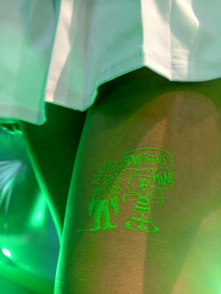 Tatuaje temporal en serigrafía fluorescente sobre el brazo de un asistente