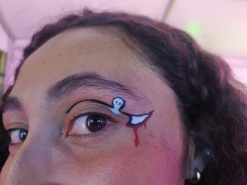 Maquillaje artístico temático aplicado alrededor del ojo de una invitada
